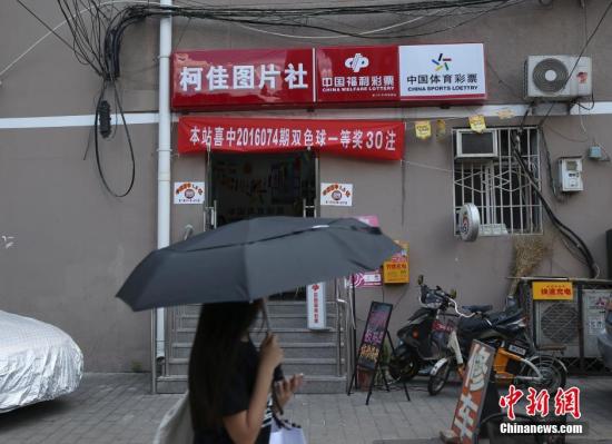 资料图：北京市海淀区海淀南路一家兼营图片社的福彩销售店张贴着中奖喜报和横幅。中新社记者