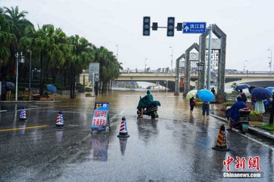 图为漓江水漫过桂林解放桥滨江路，该路段进行临时交通管制。