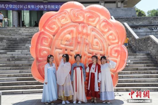 9月13日，市民穿着汉服在月饼模型前合影。当日，贵州贵阳孔学堂举办“月映万家·中秋游园”中秋节传统文化活动，吸引众多市民参与，感受中秋文化。中新社记者