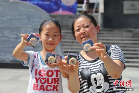 9月13日，一对母女展示亲手制作的月饼。当日，贵州贵阳孔学堂举办“月映万家·中秋游园”中秋节传统文化活动，吸引众多市民参与，感受中秋文化。中新社记者