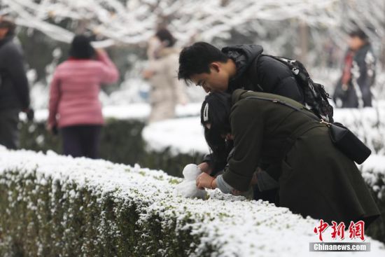 11月30日，市民在北京景山公园内堆雪人。29日，北京迎来2019年冬季初雪。中新社记者