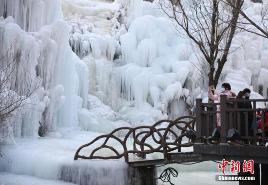 1月17日，游客在北京门头沟神泉峡风景区观赏冰瀑。千姿百态的冰瀑奇观宛若冰雪童话世界，让人惊叹不已。中新社记者