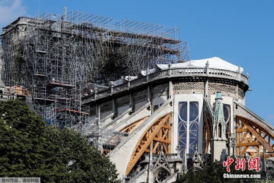 当地时间8月19日，法国巴黎圣母院修复工程重启第一天，工人戴着面罩在大教堂受损区域进行调查。由于巴黎圣母院部分建材含铅，在火灾中释出大量含铅灰尘，为保障工人健康，重建工作自7月25日暂时停止。