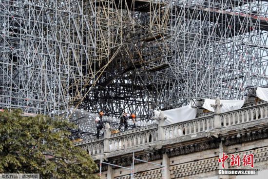 当地时间8月19日，法国巴黎圣母院修复工程第一天，工人戴着面罩在大教堂受损区域进行调查。由于巴黎圣母院部分建材含铅，在火灾中释出大量含铅灰尘，为保障工人健康，重建工作自7月25日暂时停止。