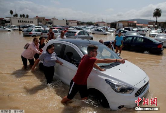 当地时间9月13日，西班牙奥里韦拉，当地一处停车场遭洪水袭击后，民众将车辆转移致安全区域。