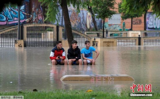 当地时间9月13日，西班牙穆尔西亚附近的奥里韦拉遭遇暴雨，男孩们坐在塞古拉河附近公园的长凳上。