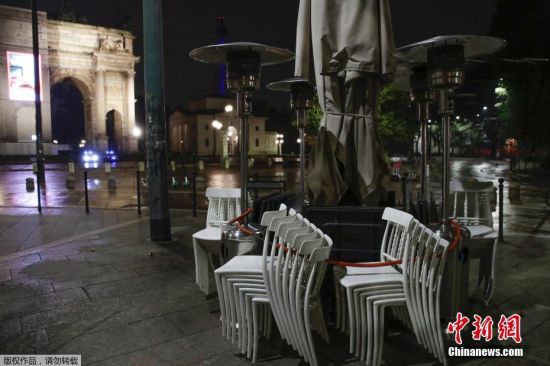 当地时间10月22日，意大利米兰，一家餐馆外摆放着堆叠的椅子。