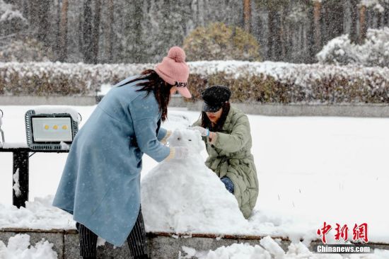 10月27日，黑龙江漠河，两名女子在雪中堆雪人。受新一轮冷空气影响，漠河迎来降雪天气。自26日夜间开始，截至当日上午，当地降雪量为7.9毫米，雪深超过10厘米，达到大雪级别。这也是当地今年入秋以来的最大一场降雪。