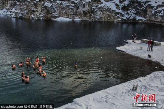 当地时间1月17日，波兰克拉科夫，当地气温已降至零下12摄氏度，民众在湖水中进行冬泳。
