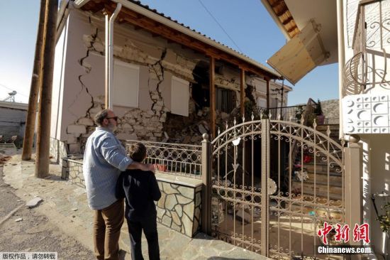 希腊中部达马西村民众看查乍地震后受损的房屋。