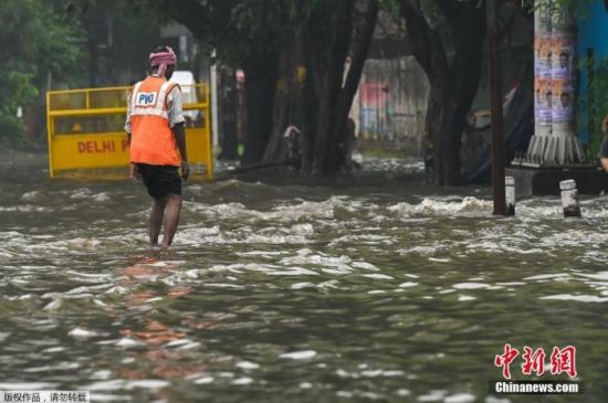 　　资料图：当地时间9月11日，印度新德里，一场暴雨过后路面积水严重，市政工人正在疏通排水设施。